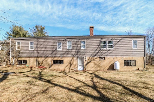 back of property featuring a yard and a chimney