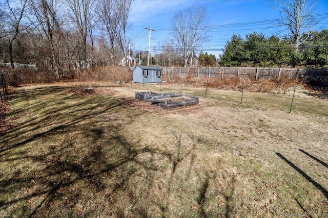 view of yard with an outbuilding, a vegetable garden, a storage unit, and fence