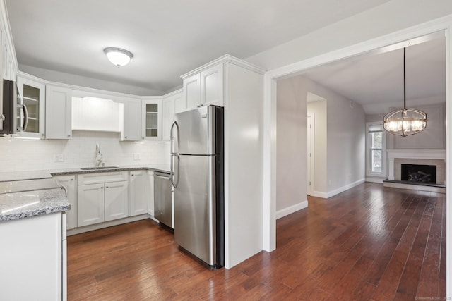 1042 Heritage Vlg Unit A, Southbury, CT 06488 - kitchen featuring stainless steel appliances, a sink, light stone counters, and glass insert cabinets