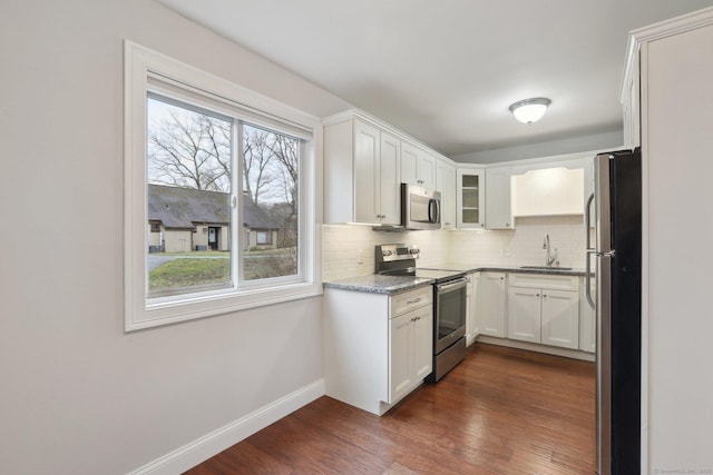 1042 Heritage Vlg Unit A, Southbury, CT 06488 - kitchen featuring appliances with stainless steel finishes, a sink, baseboards, tasteful backsplash, and dark wood finished floors