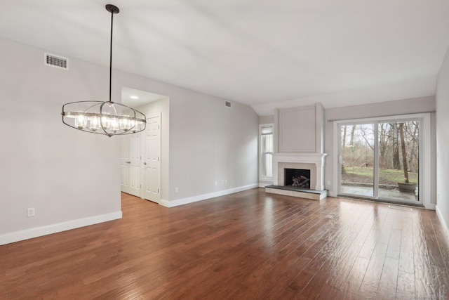 1042 Heritage Vlg Unit A, Southbury, CT 06488 - unfurnished living room featuring wood finished floors, baseboards, a chandelier, and a fireplace with raised hearth