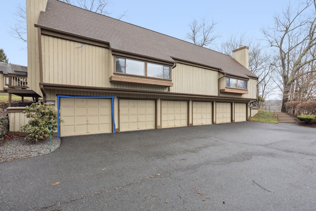 1042 Heritage Vlg Unit A, Southbury, CT 06488 - view of front of home with a chimney, a shingled roof, and community garages