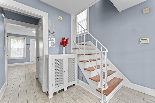 stairs featuring baseboards and wood tiled floor