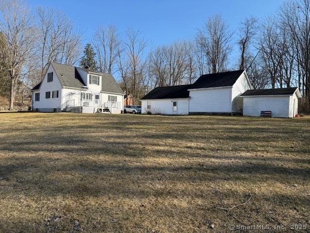 view of side of property featuring an outbuilding and a yard