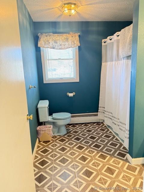 full bathroom with a textured ceiling, toilet, baseboards, and a baseboard radiator