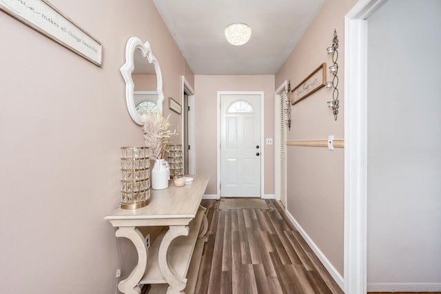 doorway featuring dark wood-type flooring and baseboards