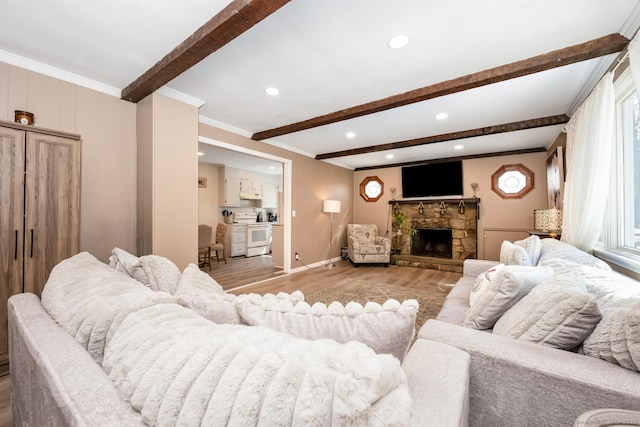 living area featuring baseboards, light wood-style flooring, a fireplace, crown molding, and beamed ceiling