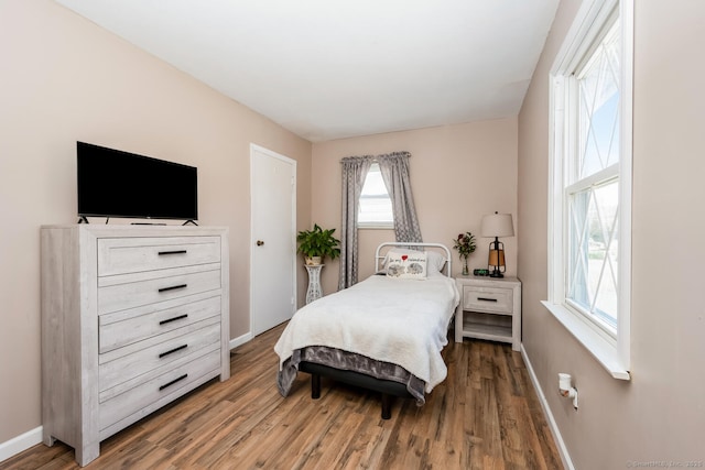bedroom featuring wood finished floors and baseboards