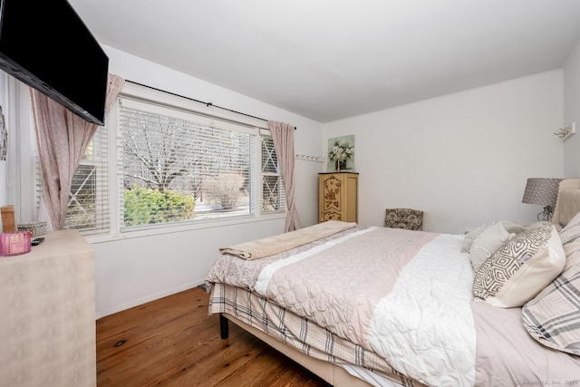 bedroom with wood finished floors and baseboards
