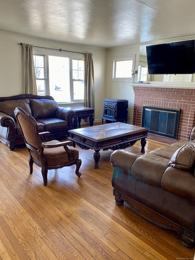 living area featuring a textured ceiling, a wood stove, and hardwood / wood-style flooring