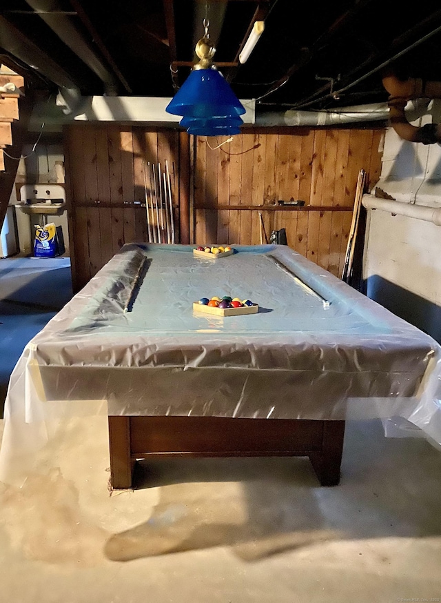 recreation room featuring wooden walls, concrete flooring, and billiards