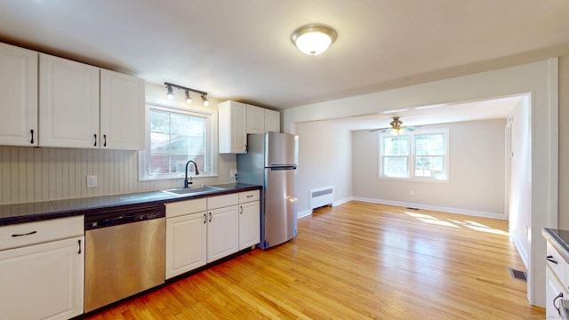 kitchen featuring dark countertops, visible vents, appliances with stainless steel finishes, and a sink