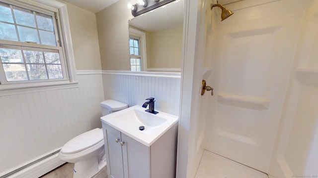 full bathroom featuring vanity, a wainscoted wall, walk in shower, a baseboard heating unit, and toilet