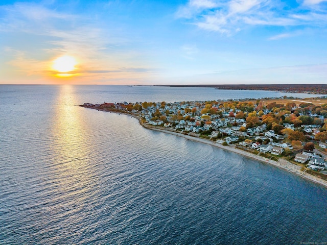 aerial view at dusk featuring a water view