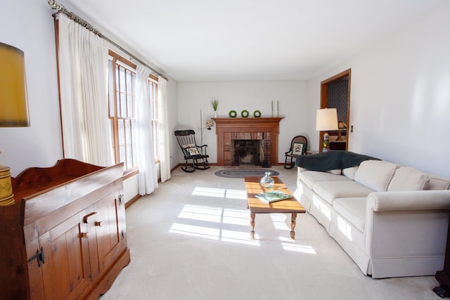 living area with light colored carpet and a brick fireplace