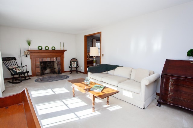 living area with a brick fireplace, baseboards, and carpet floors