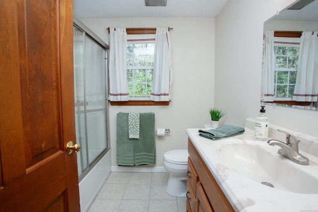 full bath with vanity, baseboards, tile patterned floors, toilet, and combined bath / shower with glass door