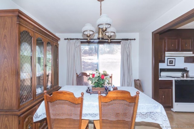 dining space with light tile patterned floors and an inviting chandelier