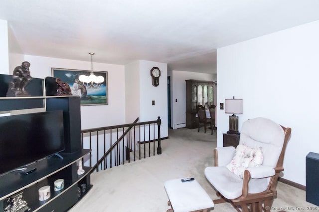 sitting room featuring baseboards, a notable chandelier, a baseboard heating unit, carpet flooring, and an upstairs landing