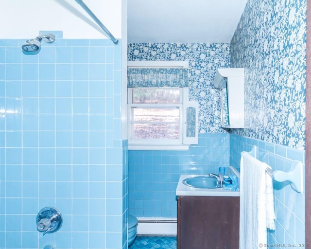 bathroom with tile patterned flooring, tile walls, a wainscoted wall, baseboard heating, and vanity