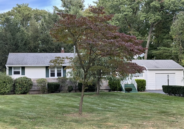 view of front facade with a chimney, a front yard, and a shingled roof