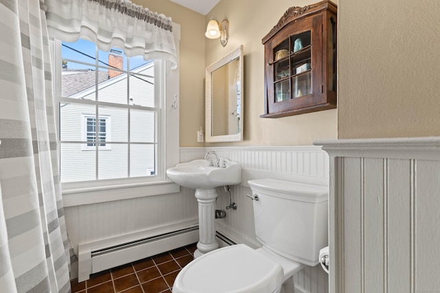 full bathroom featuring a wealth of natural light, a baseboard radiator, a wainscoted wall, and tile patterned flooring