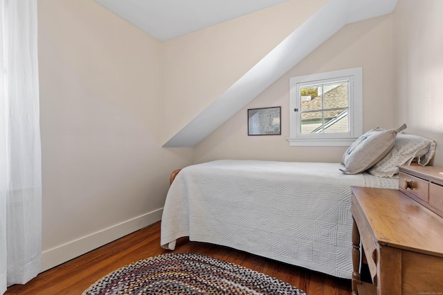 bedroom with lofted ceiling, wood finished floors, and baseboards