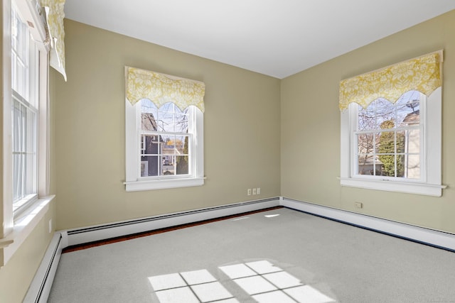 empty room featuring a baseboard heating unit and carpet floors