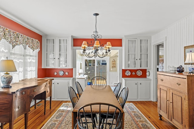 dining area featuring light wood-style floors and an inviting chandelier