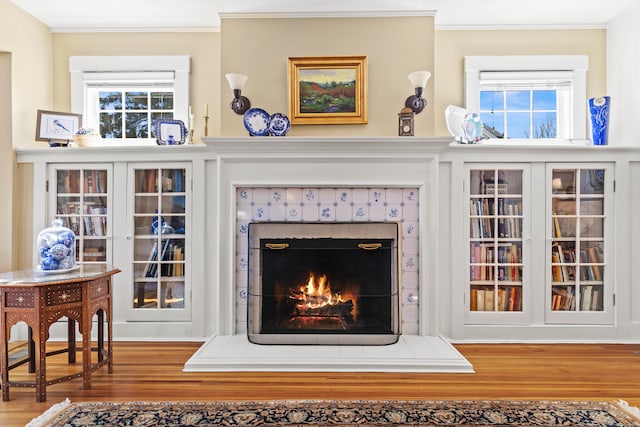 living room with plenty of natural light, crown molding, and wood finished floors