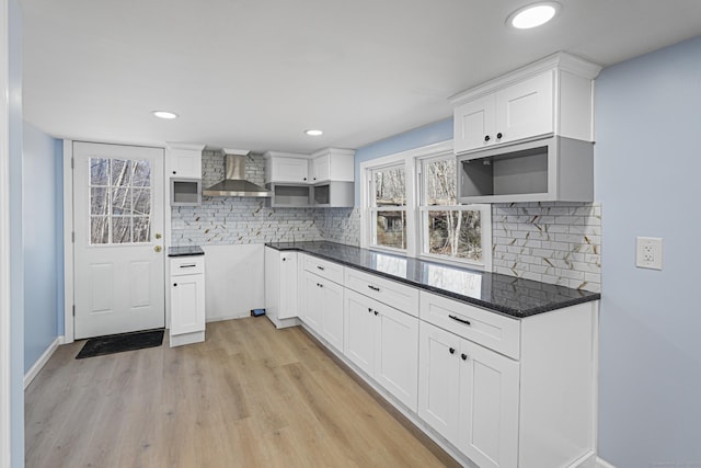 129 Smith Rd, East Haddam, CT 06423 - kitchen with white cabinets, wall chimney range hood, baseboards, light wood-style flooring, and tasteful backsplash