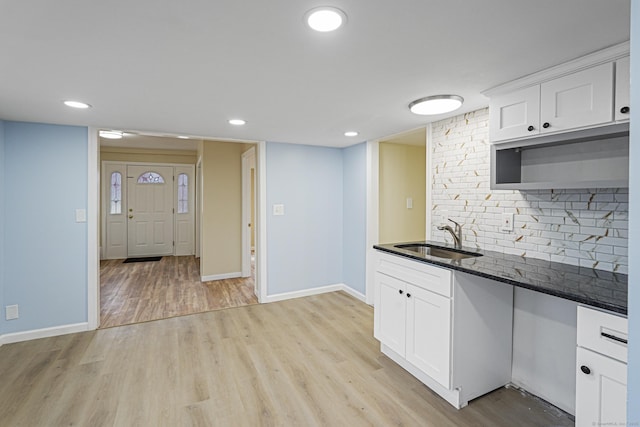 129 Smith Rd, East Haddam, CT 06423 - kitchen featuring dark stone countertops, a sink, white cabinets, light wood-style flooring, and backsplash