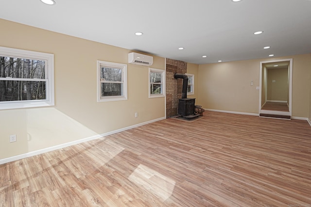 129 Smith Rd, East Haddam, CT 06423 - unfurnished living room featuring recessed lighting, a wood stove, light wood-style floors, and a wall unit AC