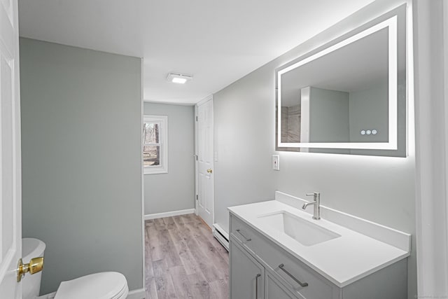 129 Smith Rd, East Haddam, CT 06423 - bathroom featuring a baseboard radiator, wood finished floors, vanity, baseboards, and toilet
