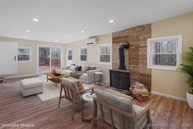129 Smith Rd, East Haddam, CT 06423 - living room featuring an AC wall unit, baseboards, and wood finished floors