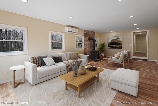 129 Smith Rd, East Haddam, CT 06423 - living room with recessed lighting, a wall mounted AC, light wood-style floors, and a wood stove
