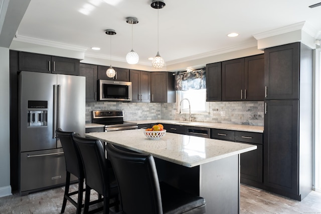 kitchen featuring a center island, crown molding, a breakfast bar area, stainless steel appliances, and a sink