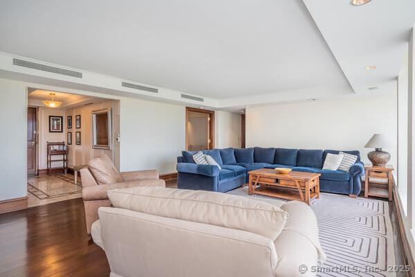 living area featuring visible vents, baseboards, and wood finished floors