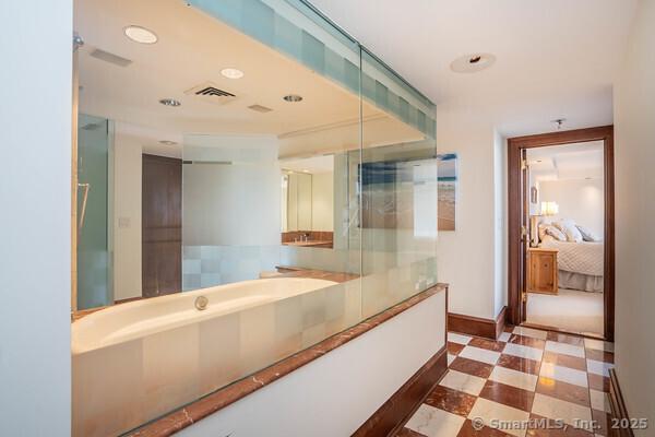 ensuite bathroom featuring visible vents, baseboards, a garden tub, ensuite bathroom, and tile patterned floors