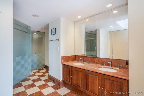 bathroom featuring a sink, backsplash, double vanity, and tile patterned floors