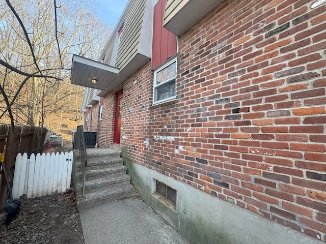 view of side of property with fence and brick siding