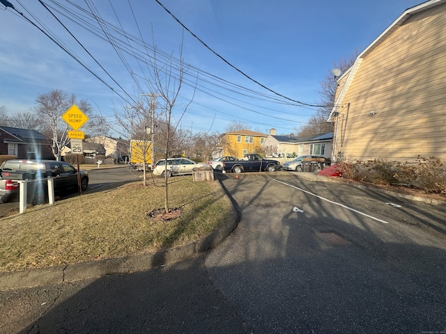 view of road with a residential view, curbs, and traffic signs