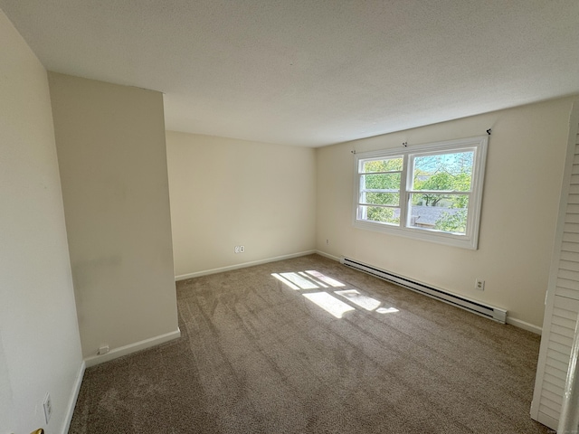 empty room with a textured ceiling, baseboards, a baseboard heating unit, and carpet