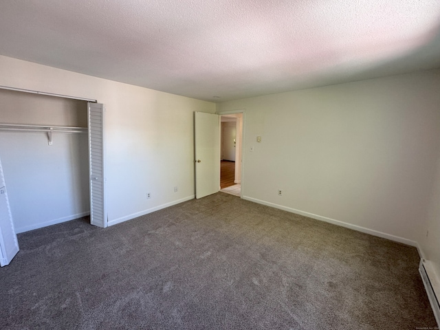 unfurnished bedroom with baseboards, carpet floors, a baseboard radiator, a closet, and a textured ceiling