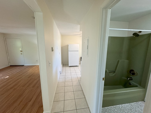 hallway featuring baseboards and light tile patterned flooring