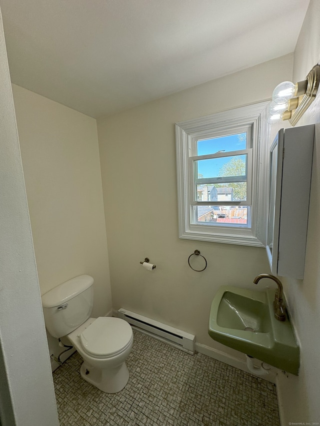 bathroom with a sink, a baseboard heating unit, toilet, and tile patterned flooring