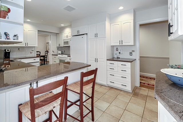 68 Hawthorne Dr, Fairfield, CT 06825 - kitchen with white appliances, open shelves, decorative backsplash, a kitchen breakfast bar, and a peninsula