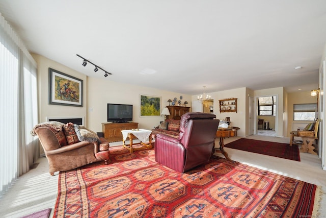 living room with light carpet, a chandelier, and rail lighting