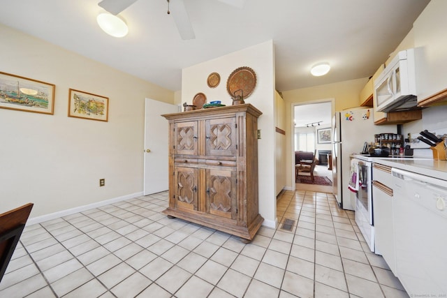 kitchen with white appliances, baseboards, light countertops, ceiling fan, and light tile patterned floors