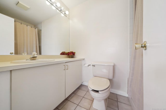 full bathroom featuring toilet, tile patterned flooring, vanity, and baseboards